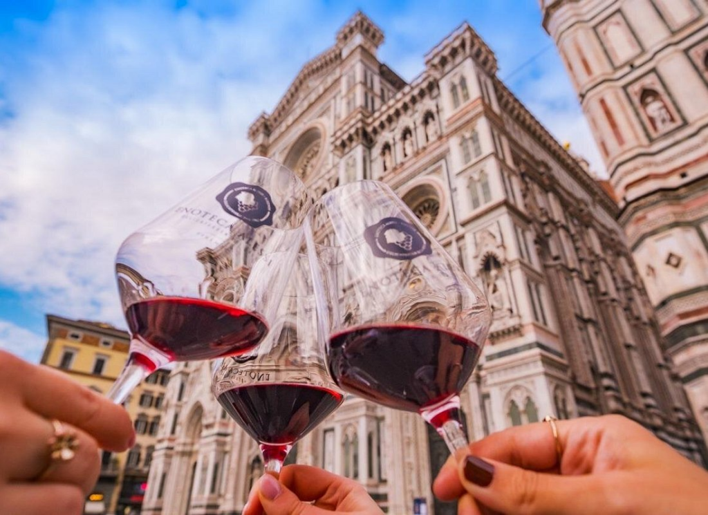 Glasses of Tuscan red wine raised in front of Florence Cathedral, a memorable city moment on florence wine tours.