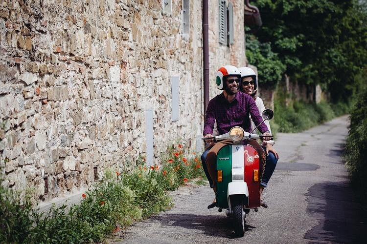 Two riders exploring a quiet Tuscan lane during a vespa wine tour florence
