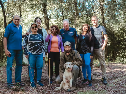 Small group posing with guide and truffle dog during truffle hunting Florence tour in Tuscany forest.