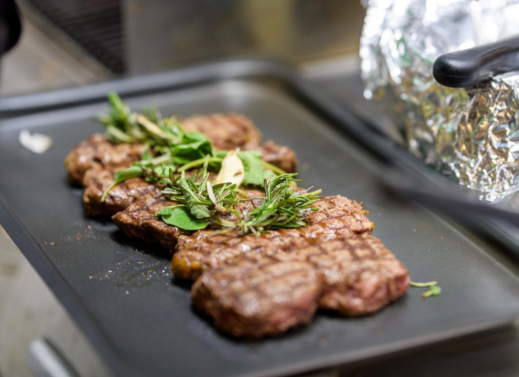 Grilled Tuscan steak with fresh herbs served during a florence food and wine walking tour tasting stop in Florence.