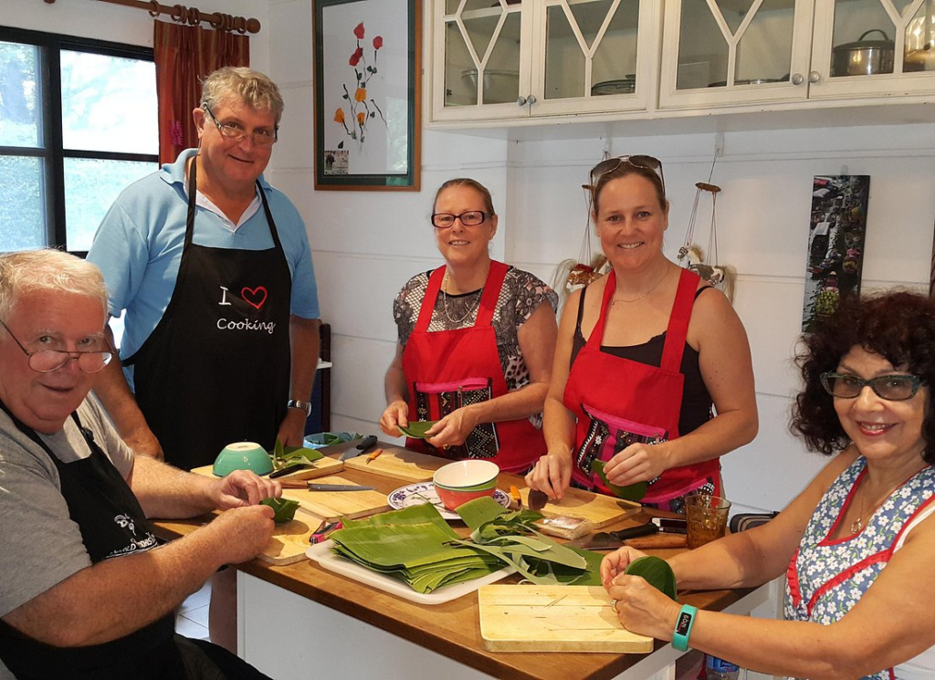 Students preparing banana leaf ingredients during one of the Best Thai Cooking Classes in Bangkok