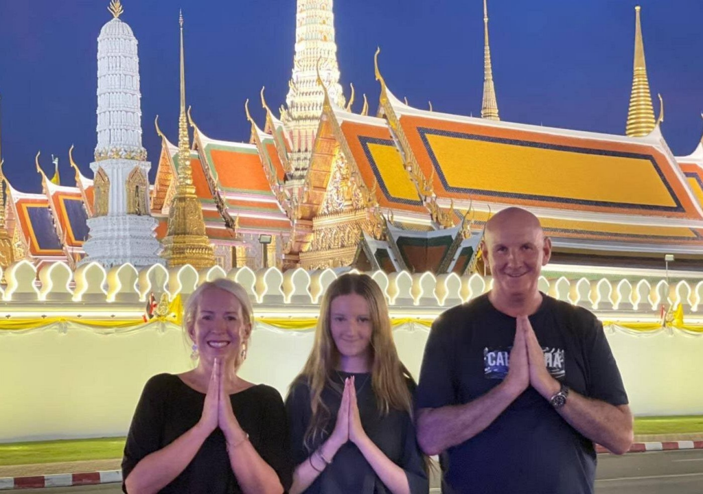 Travelers posing at Bangkok temple during a nighttime stop on a tuk tuk food tour Bangkok