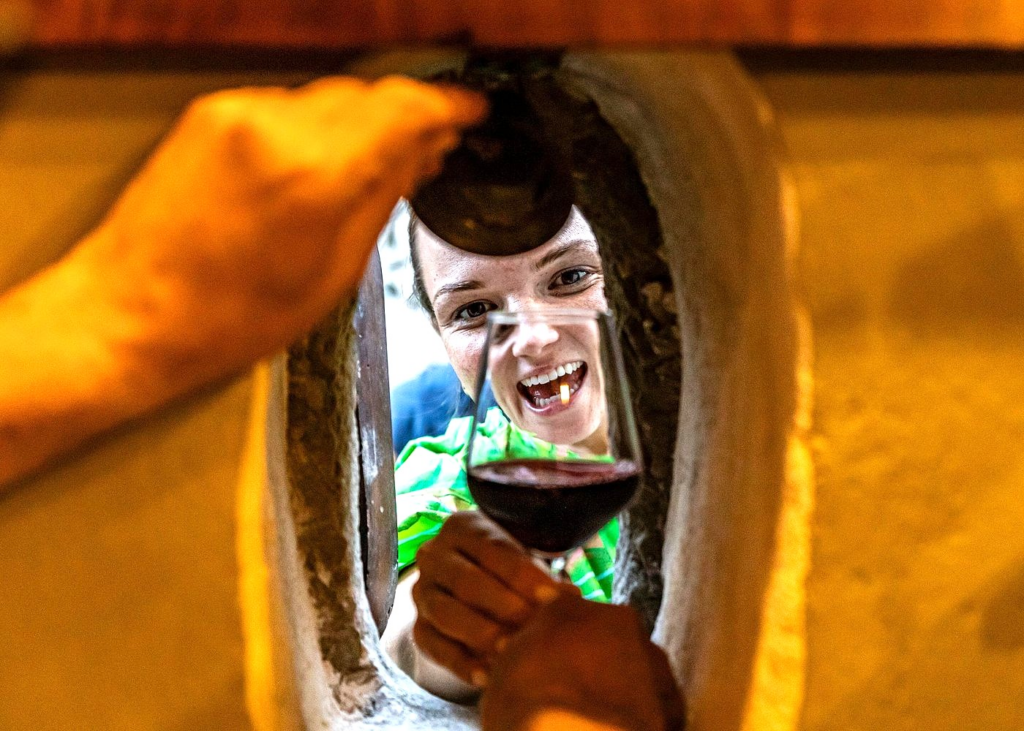 Wine being served through a traditional Florence wine window (buchetta del vino) during a Florence food and wine tour experience