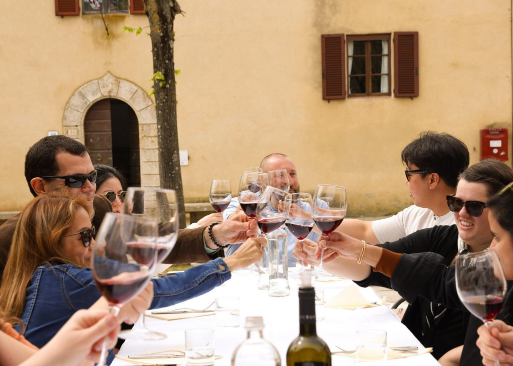 Group toasting with red wine during a Florence food and wine tour at an outdoor Tuscan setting