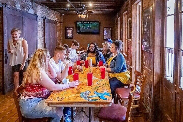Group of diners enjoying a meal and conversation inside a rustic French Quarter restaurant on one of the best food tours in New Orleans.