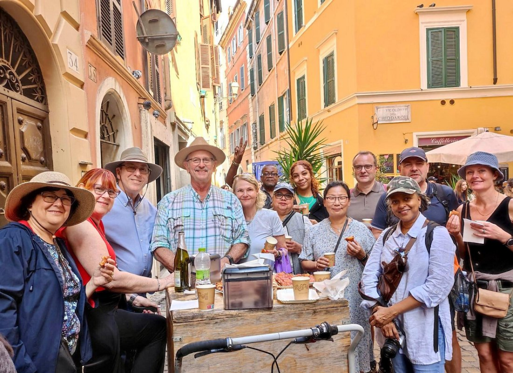 Tour group eating local specialties on rome street food tours along a charming street in Rome