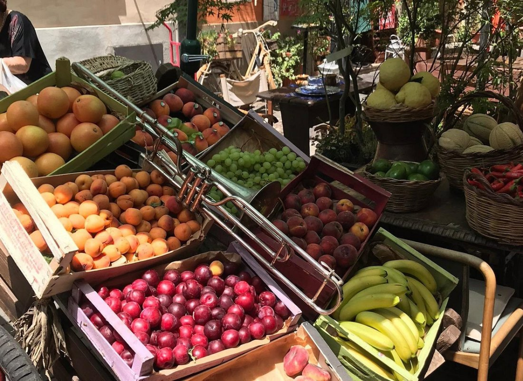 Assorted fresh fruit including peaches, grapes, and bananas on display during rome market tours at a local Rome market