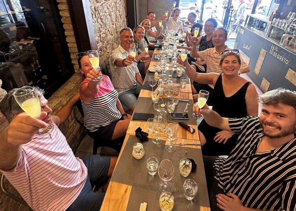 Wine tasting Rome group enjoying a toast with glasses of Italian wine in a cozy restaurant setting