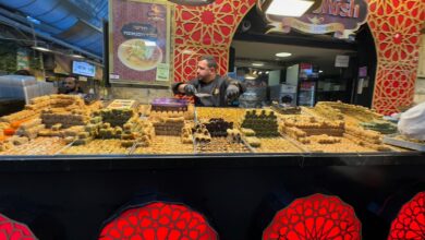 Jerusalem Food Tours feature a colorful baklava and Middle Eastern sweets stall at Mahane Yehuda Market, where visitors can sample traditional desserts and local specialties.