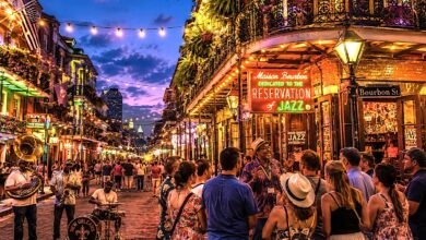 A guided group explores Bourbon Street at dusk with live jazz musicians, glowing balconies, and vibrant nightlife on one of the best tours in New Orleans.