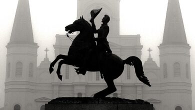 Haunted pub crawl New Orleans featuring the Andrew Jackson statue silhouetted in front of St. Louis Cathedral on a foggy night in Jackson Square.