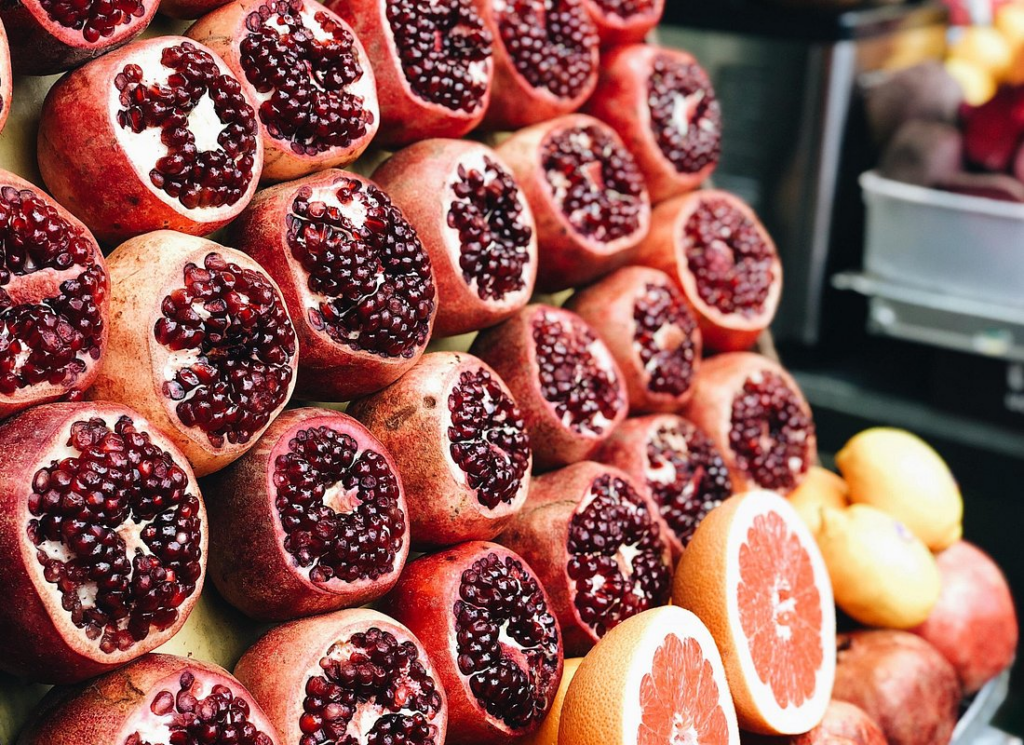 Carmel Market Tel Aviv showcasing vibrant displays of freshly cut pomegranates, citrus fruits, and seasonal produce at one of the city's most iconic open-air food markets.