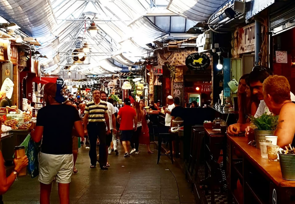 Jerusalem Food Tours explore the lively aisles of Mahane Yehuda Market, where bustling food stalls, cafΓ©s, and local vendors create a vibrant culinary atmosphere.