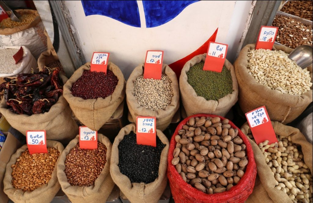 Sacks of dried beans, nuts and legumes displayed at a traditional Tel Aviv market, a colorful stop on Israel food and market tours.