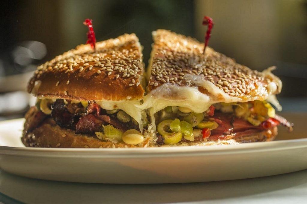 A classic New Orleans muffuletta sandwich served fresh at a local eatery, a delicious stop on a New Orleans cocktail tour.