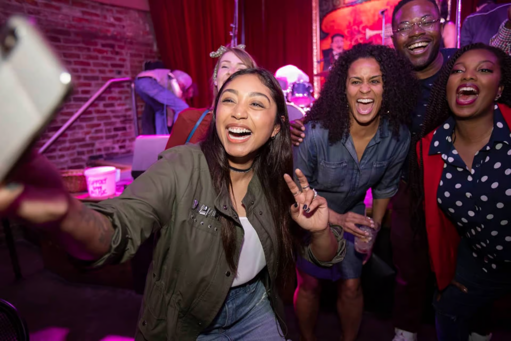 Friends taking a selfie at a lively music venue during a New Orleans cocktail tour, enjoying the city's vibrant nightlife.