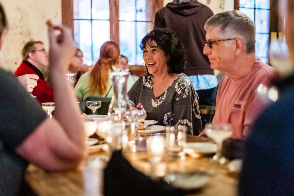 Guests enjoying dinner and classic cocktails at a historic restaurant during a New Orleans cocktail tour in the French Quarter.