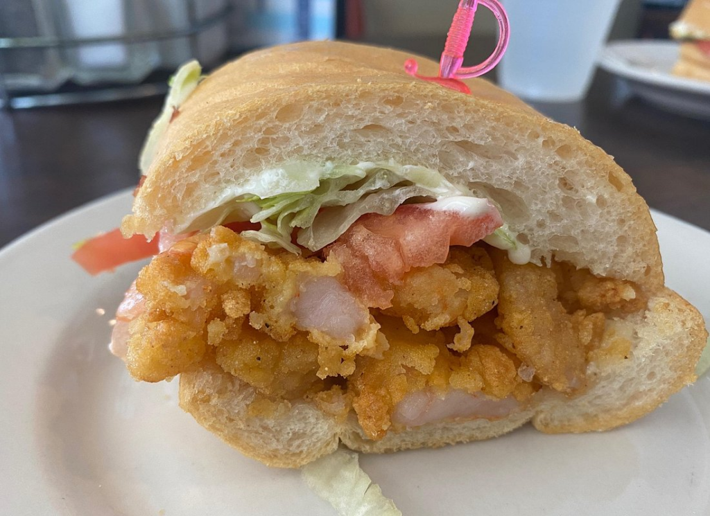Crispy fried shrimp po'boy topped with lettuce, tomato, and mayonnaise on fresh French bread, a favorite on the best food tours in New Orleans.