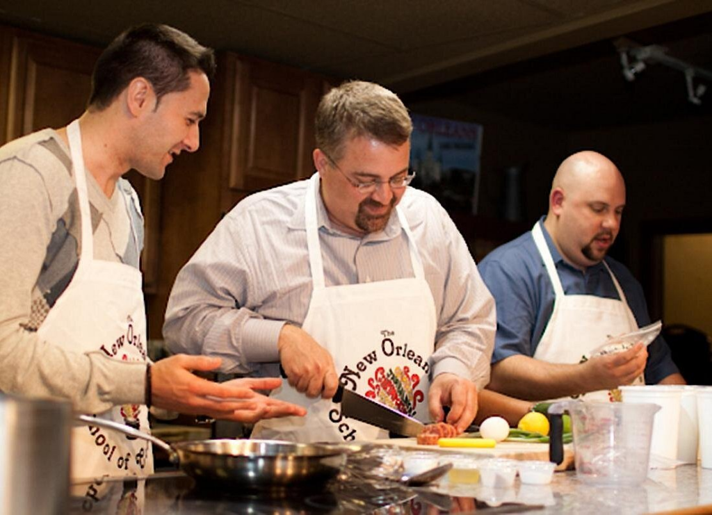 Participants preparing authentic Louisiana dishes during a hands-on cooking class New Orleans experience with professional instruction.