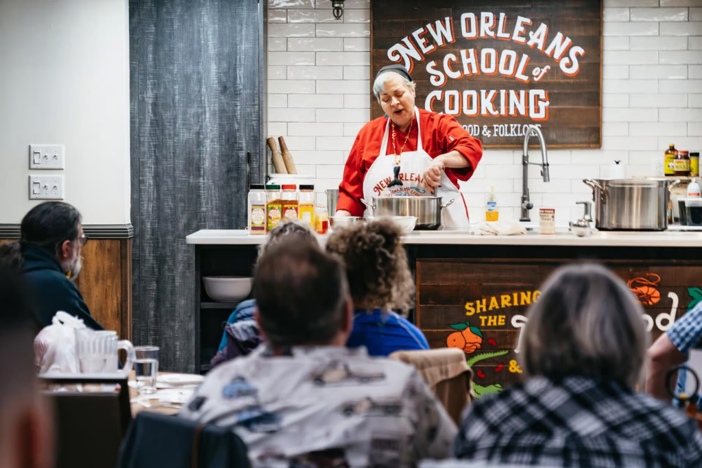 A chef demonstrating classic Creole cooking techniques during a cooking class New Orleans experience at a professional teaching kitchen.