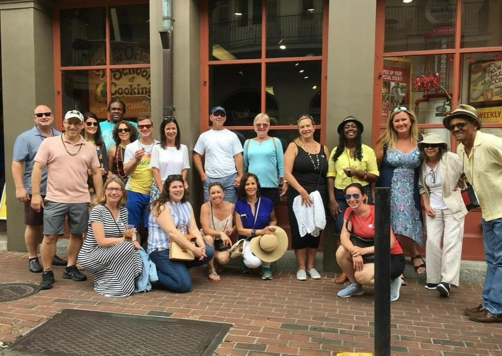 New Orleans food walking tour with a group of food lovers posing outside a French Quarter restaurant during a guided culinary tasting experience.