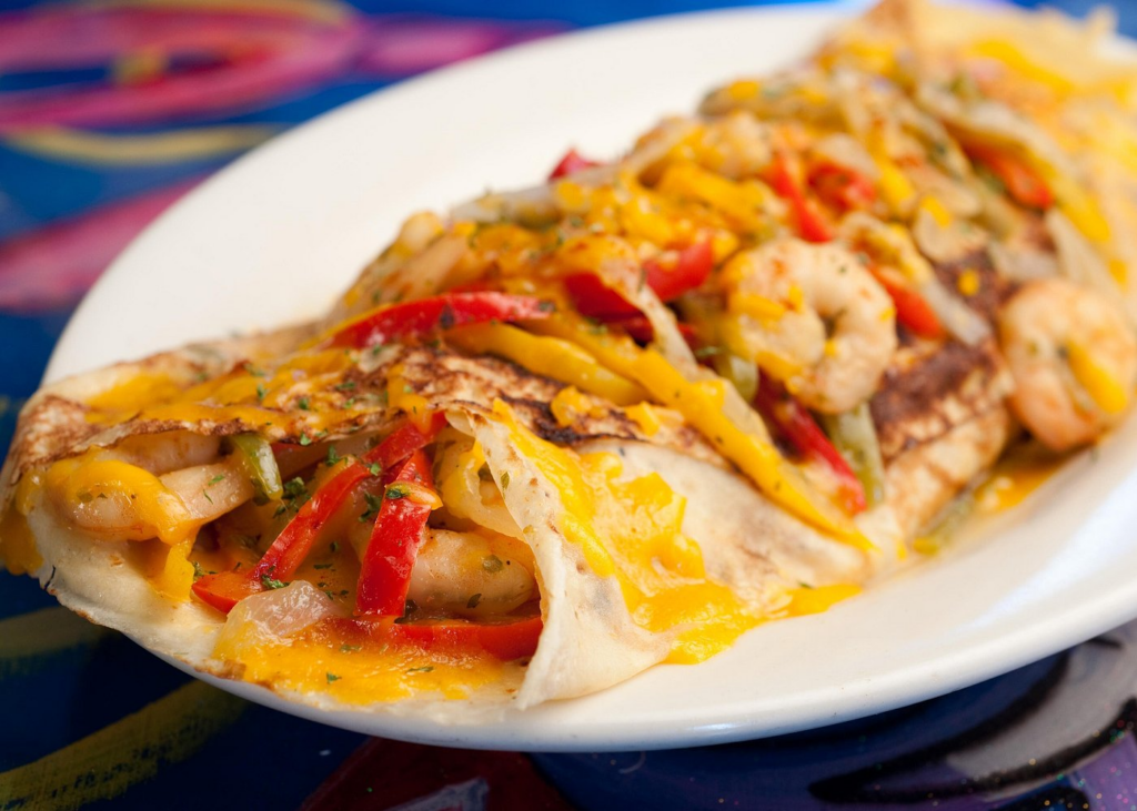 A cheesy shrimp quesadilla filled with Gulf shrimp, sautéed peppers, onions, and melted cheddar is served during a French Quarter food tour, showcasing a flavorful New Orleans seafood favorite.
