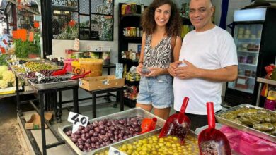 tel aviv food tours exploring a vibrant market stall with local vendors, olives, pickled vegetables, and traditional Mediterranean delicacies in Tel Aviv.